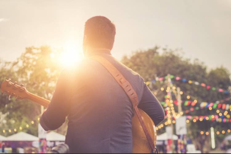 man on stage playing guitar