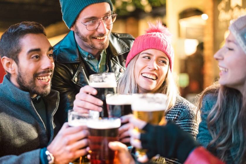 Friends clinking beer glasses during winter apres ski