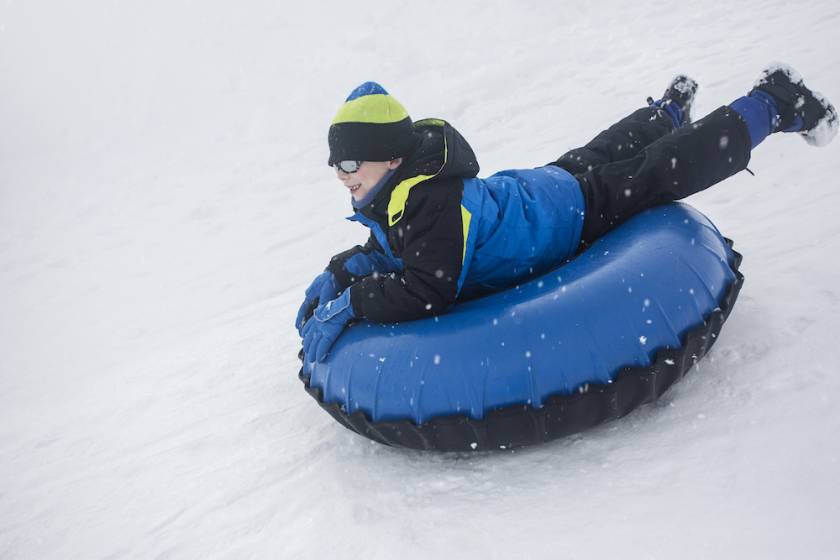 Little boy snow tubing